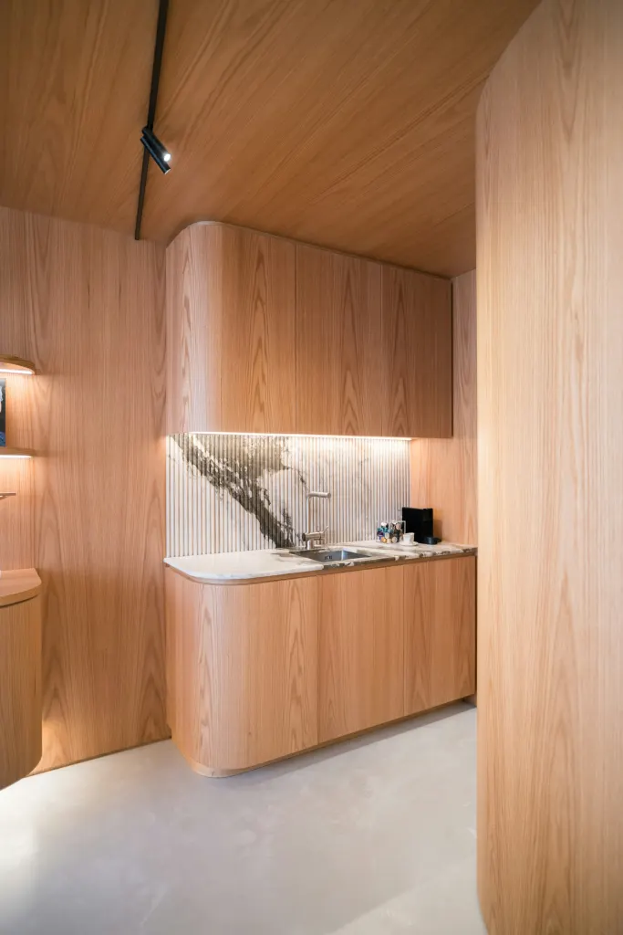 A curved oak wall that hides the pantry and the fridge