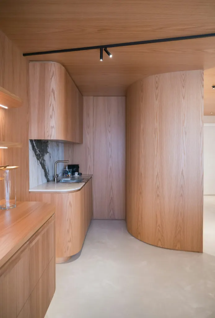 Curved oak cabinets and a marble counter