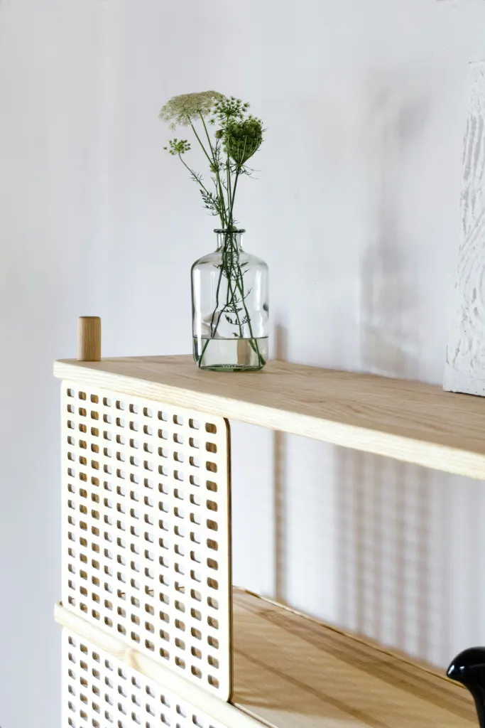 An oak shelf with a vase of flowers