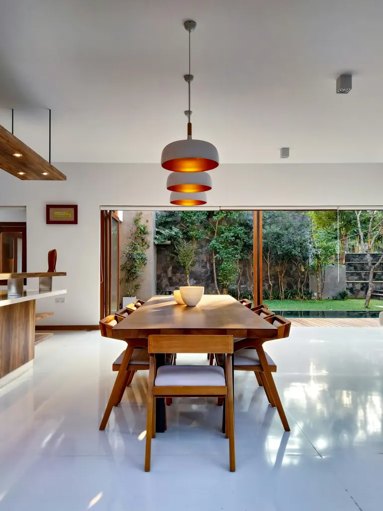 A pendant lamp above an oak table
