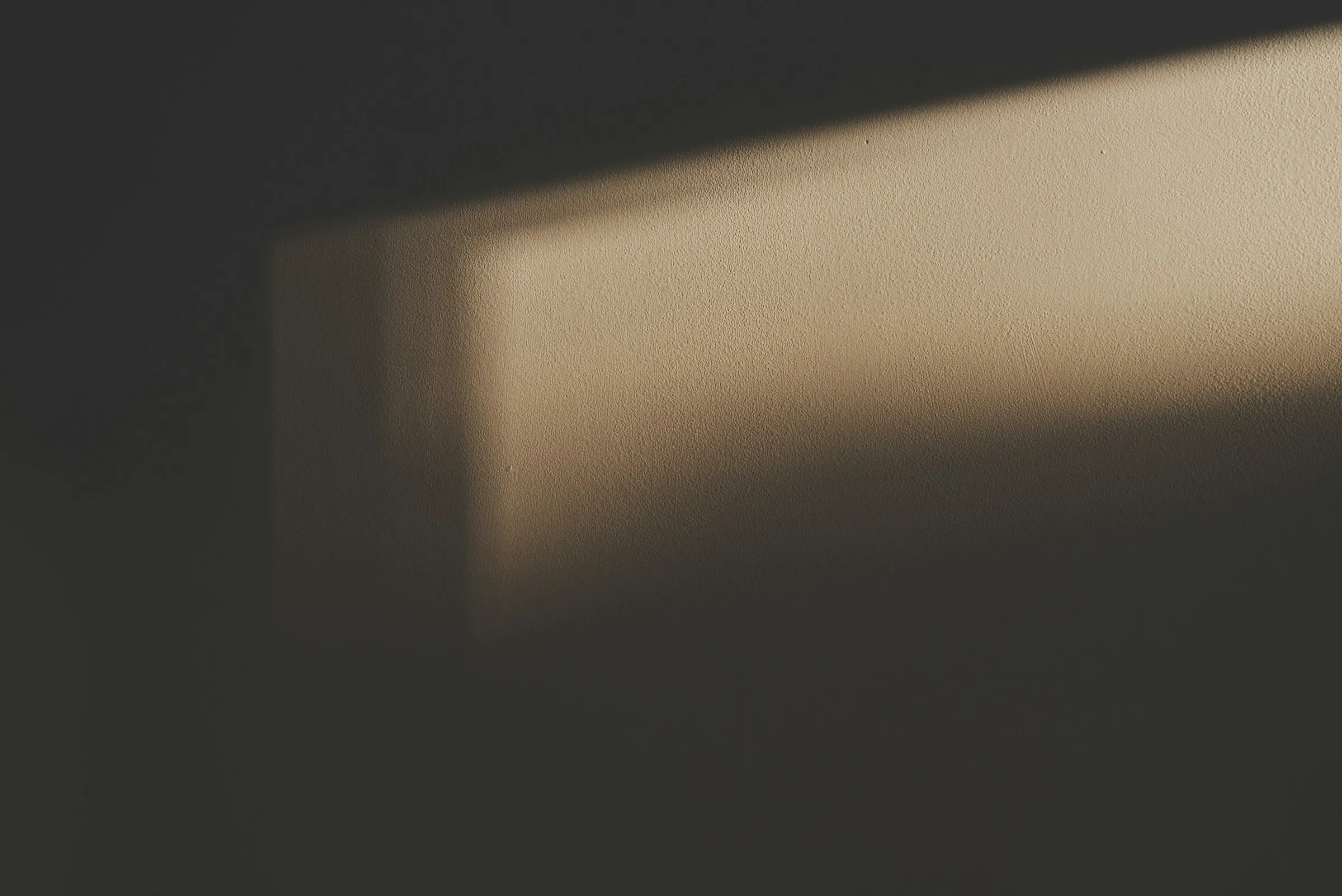 Morning light drawing a window on a dark wall