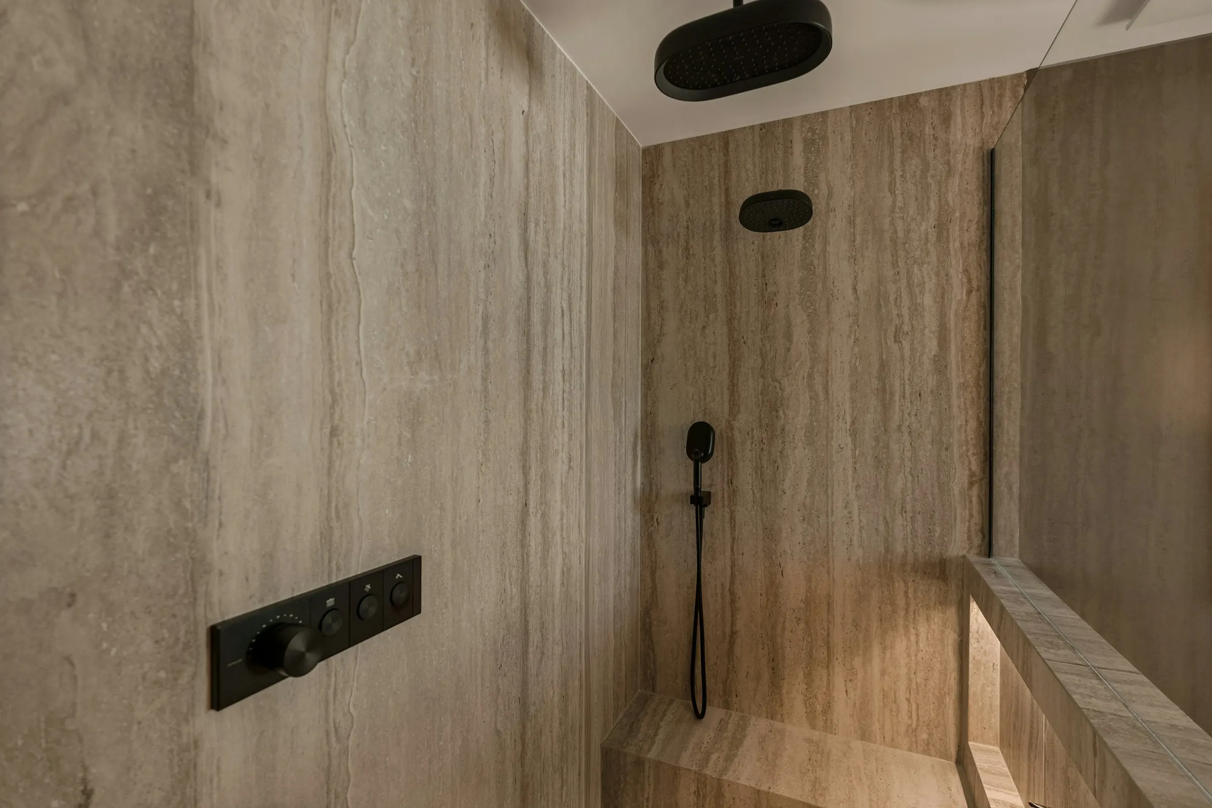 A shower clad in brushed travertine